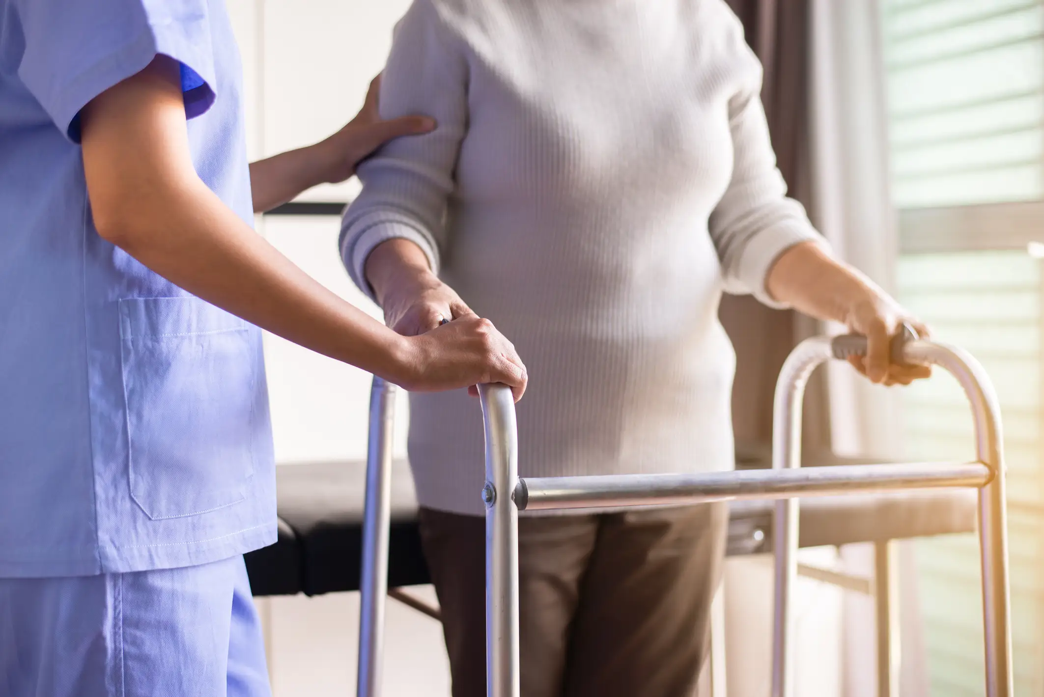 Caregiver supporting a senior resident with a walker